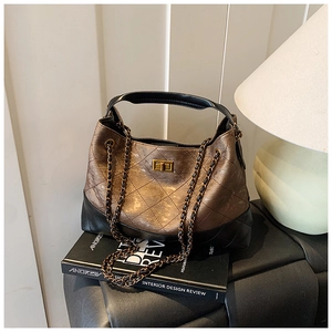 Detail of quilted leather texture and golden metal twist lock on the crossbody bag