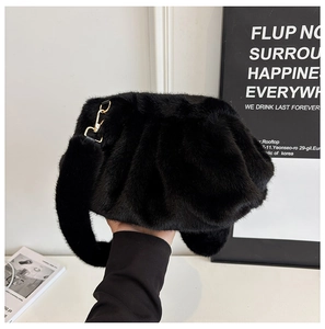 Detail view of black faux fur cloud bag with soft pleated texture and gold metal hardware
