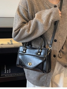 Elegant black faux leather crossbody bag with gold twist lock and adjustable shoulder strap