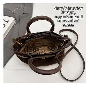Detail view of brown suede handbag with striped lining and internal storage pocket