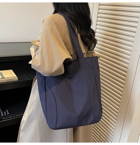 Detail of dark blue large capacity tote bag with Midota embroidery and sturdy shoulder straps