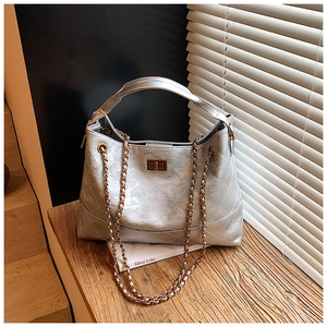 Detail of silver quilted hobo bag with vintage metal turn-lock and chain strap