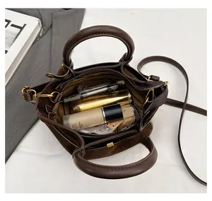 Macro view of the brown frosted suede handbag showing internal capacity for daily items