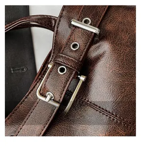Close-up of brown vintage leather bag with silver buckle and stitch details