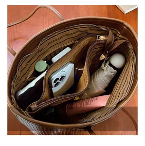 Detail showing spacious interior of brown tote bag with central zipper compartment