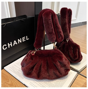 Detail of burgundy faux fur cloud bag with plush pleated texture and gold hardware