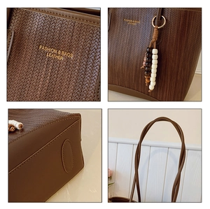 Detail of dark brown woven tote bag featuring logo embossing and beaded charm accessory