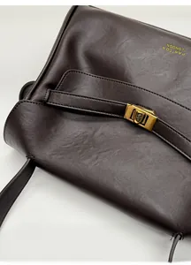 Close-up of vintage dark coffee leather tote with gold twist lock and branding detail