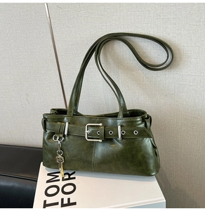 Detail of vintage dark green tote bag featuring a leather strap buckle and key pendant