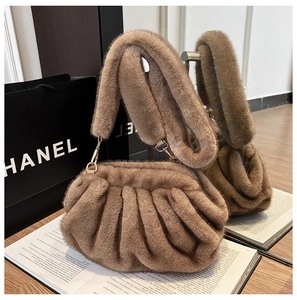 Detailed macro of brown faux fur pleated cloud bag with elegant gold metal hardware
