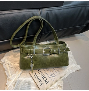 Detailed view of vintage green leather bag with metal buckle and key charm on lace