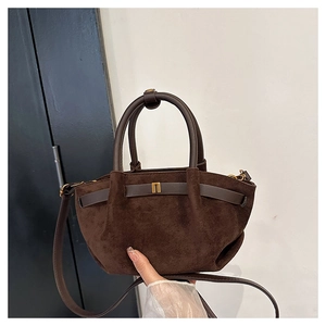 Detail of dark brown matte suede handbag showing premium texture and metallic buckle