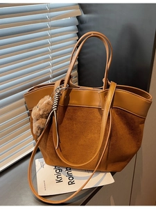 Brown vintage leather tote bag with dual handles and plush bear charm for women