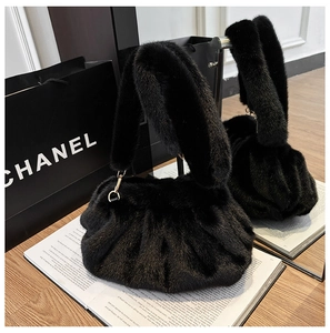 Detail of black faux fur cloud bag showing fluffy texture and elegant gold hardware