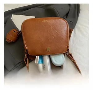 Brown vintage saddle bag with tassel detail showing interior capacity for essentials