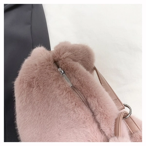Close-up of pink faux fur crossbody bag with smooth leather strap and silver metal zipper
