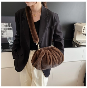 Detail of soft brown faux fur cloud bag with wide plush strap and gold metal clasp