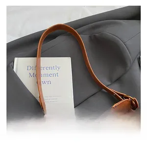 Detailed close-up of retro brown handbag showing leather texture and gold metal buckle