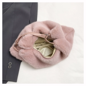 Close-up of pink faux fur handbag with leather handle and soft fluffy texture