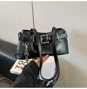 Close-up of black oil-wax leather shoulder bag with silver buckle and fashion key charm
