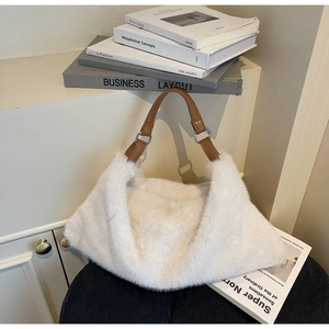 Détail du sac cabas en fausse fourrure blanche avec anses en cuir marron et anneaux