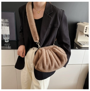 Close-up of light brown faux fur cloud bag with pleated texture and gold metal hooks