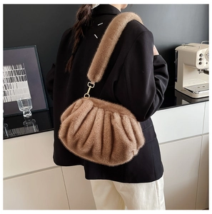 Close-up of fluffy pleated cloud bag in camel faux fur with wide shoulder strap