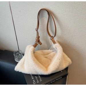 Détail du sac à bandoulière en peluche blanc cassé avec bandoulière en cuir marron