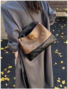 Rear view of a vintage chain shoulder bag featuring brown texture and black quilted leather