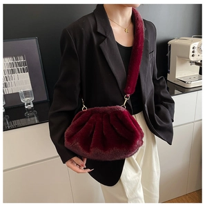 Detail view of burgundy faux fur cloud bag with plush shoulder strap and gold hardware