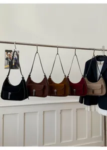 Row of vintage suede hobo bags in five different colors with metal buckle flap pockets