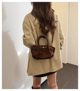 Detail view of dark brown frosted suede Boston bag with gold buckle and adjustable strap