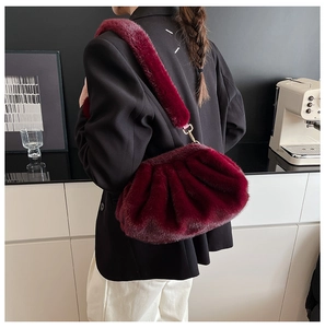 Macro view of burgundy faux fur cloud bag with soft pleats and plush strap detail