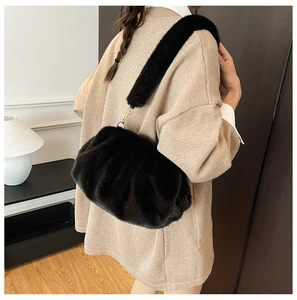 Detail of black faux fur cloud bag with plush shoulder strap and gold hardware