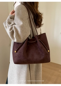 Detail of retro tote bag featuring suede texture and gold sphere drawstring charms