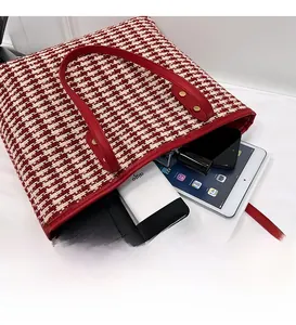Detail view of red houndstooth tote bag interior showing large capacity for gadgets