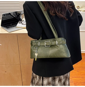 Close-up of dark green PU leather bag with silver buckle and key-shaped charm