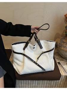 Détail du cabas en peluche blanche avec bandoulière en cuir marron et boucle dorée