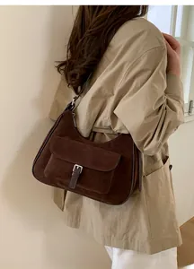 Detail view of a vintage brown suede tote bag with a silver buckle pocket and stitching