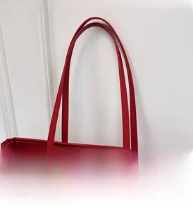 Detail of red houndstooth woven tote with leather handle and vintage metal rivets