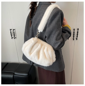 Detail of white faux fur cloud bag with plush shoulder strap and gold metal hardware