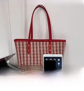 Detail of red and cream woven tote bag showing its large capacity for a tablet and phone