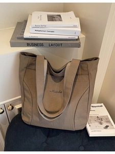 Brown canvas tote bag with Midolal embroidery on a stylish blue corduroy surface