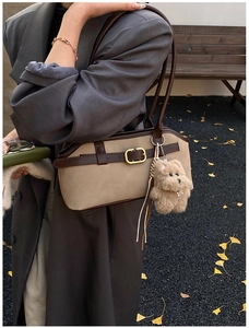 Detail der Vintage-Schultertasche mit Wildleder-Patchwork und braunem Plüsch-Anhänger