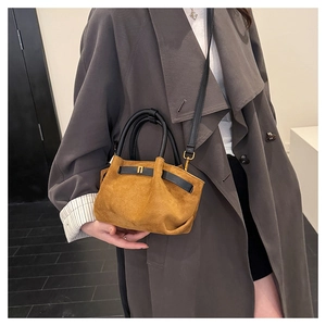 Detail of vintage brown frosted handbag showing circular handle and soft suede texture