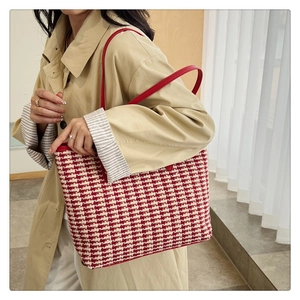 Detail of red and white tweed tote bag worn over a trench coat for elegant styling