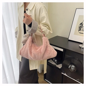 Dettaglio della borsa a tracolla in peluche rosa con manico in pelle e ciondolo orso