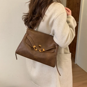Detail of the brown leather tote bag showing the gold buckle and PanTon London logo