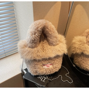 Détail d'un sac à main en fausse fourrure beige avec texture pelucheuse et étiquette texte