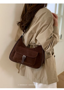 Dark brown suede half-moon shoulder bag shown on model for a minimalist retro look